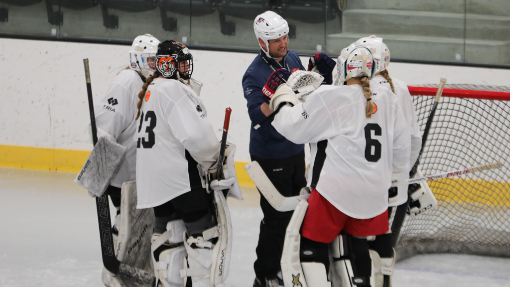 Coach on rink with players